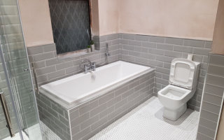 Bathroom renovation with grey metro tiles and white penny tiles